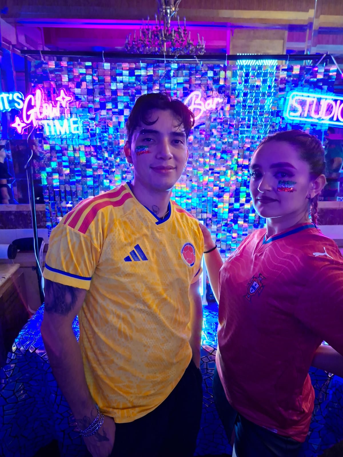 Invitados posando frente al Glitter Bar iluminado