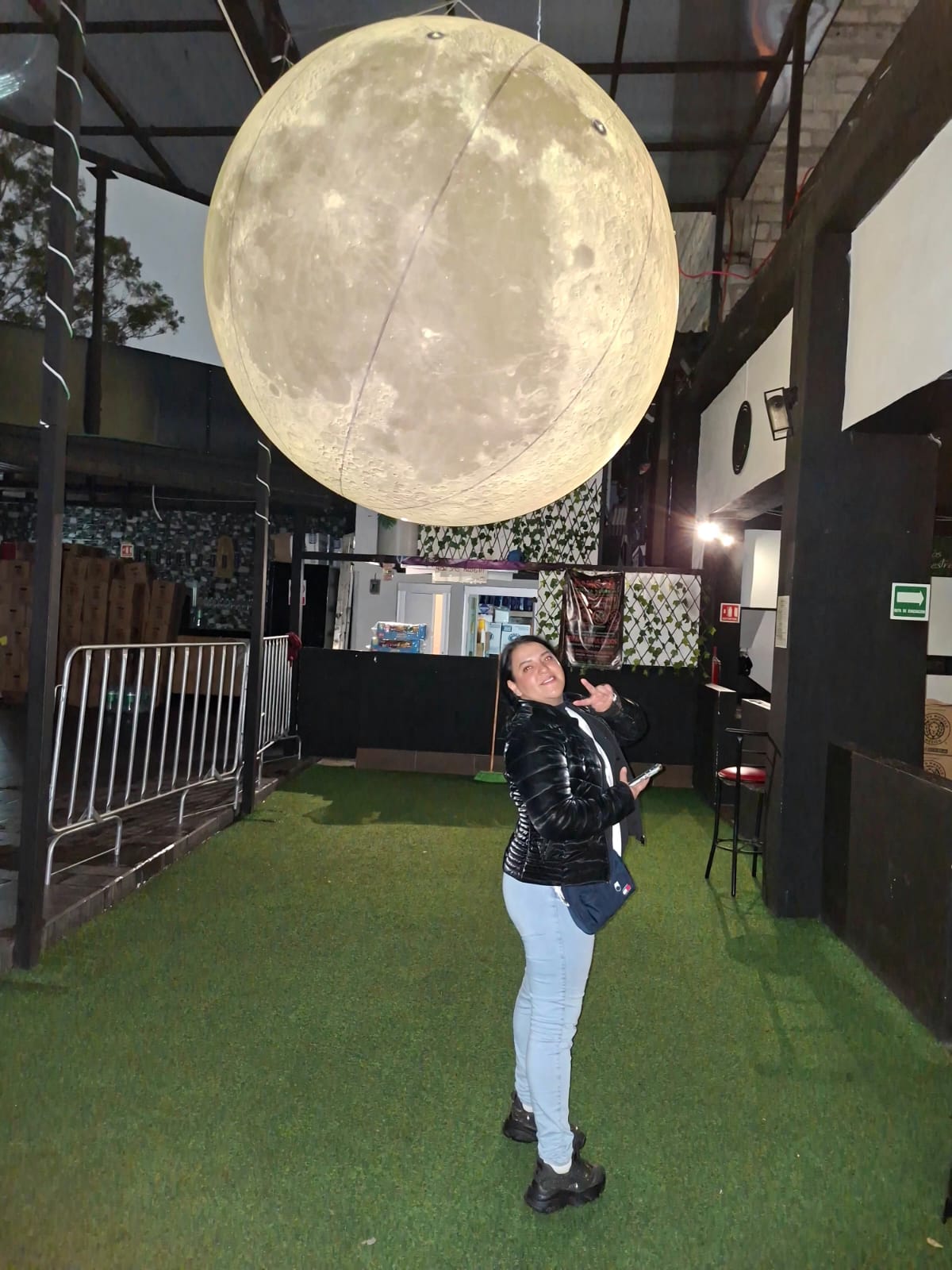 Luna Gigante Hiperrealista iluminada en dorado junto a una invitada